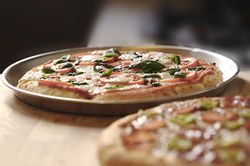 Fresh baked pizzas with basil on pizza pans