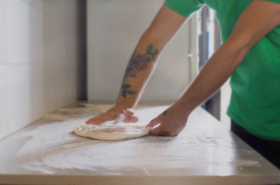 Hands stretching fresh pizza dough